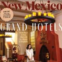 New Mexico Magazine Cover Photo with woman traveler carring suitcase in grand adobe New Mexico Hotel