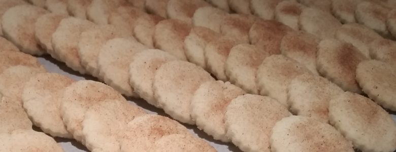 Rows of fresh baked bizcochito cookies on a baking sheet