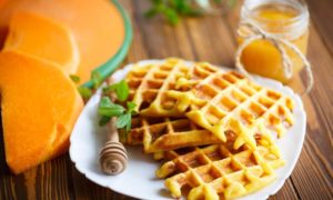 A white plate topped with homemade pumpkin waffles.