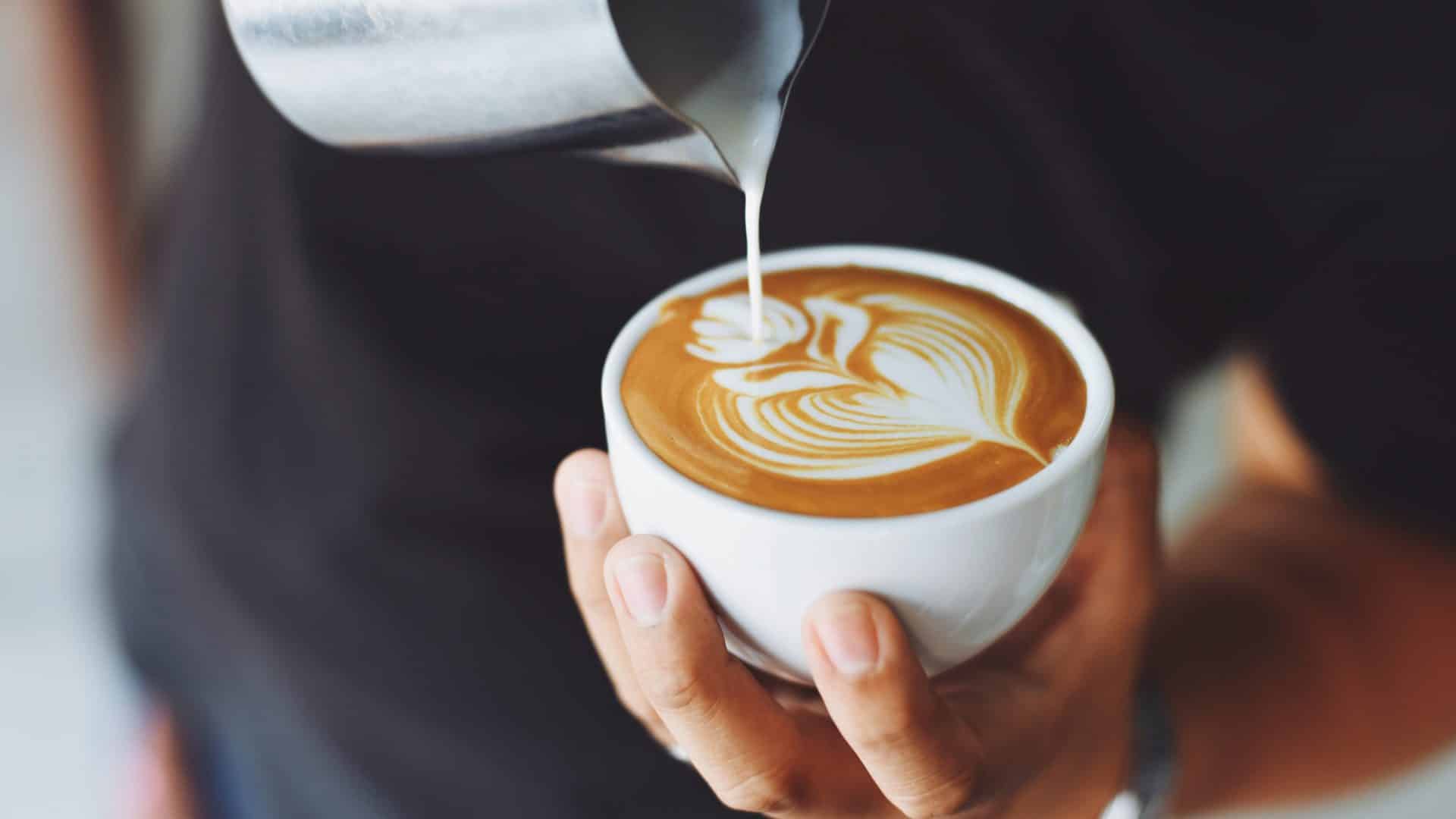 Barista pouring cream into cup for a decorative latte|Child Looking Up at Sky in front of museum