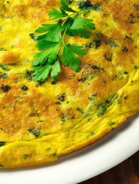 White Plate with Green Chile Frittata on it garnished with sprig of cilantro