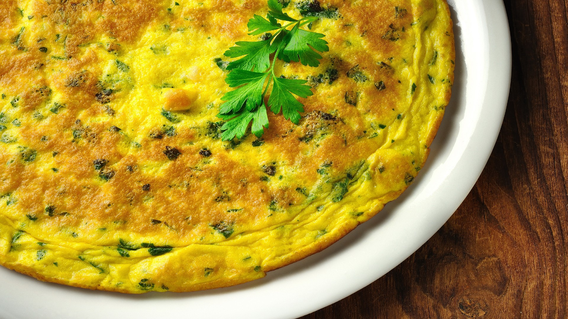 White Plate with Green Chile Frittata on it garnished with sprig of cilantro