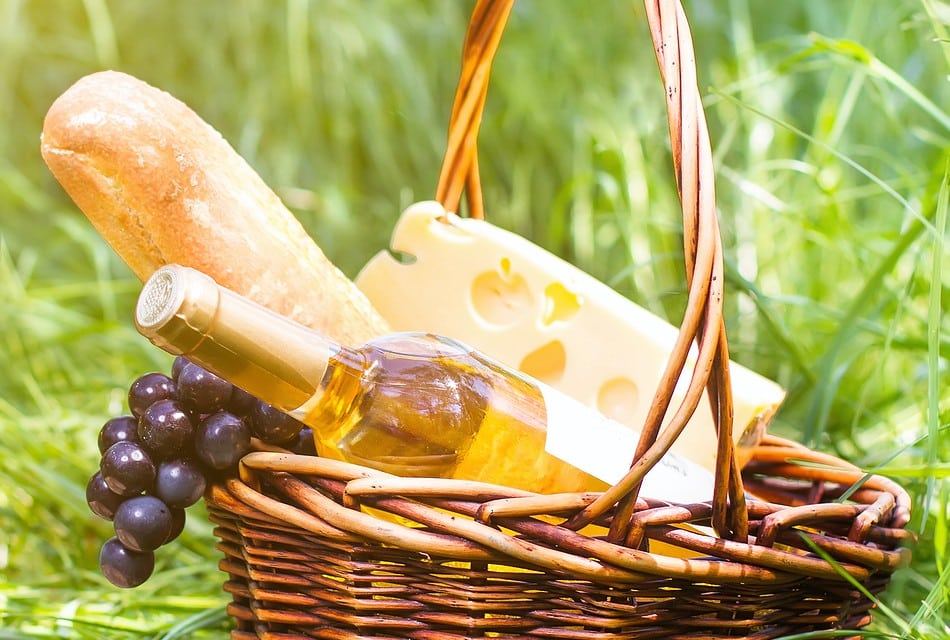 Basket with bread, fruit, cheese and wine