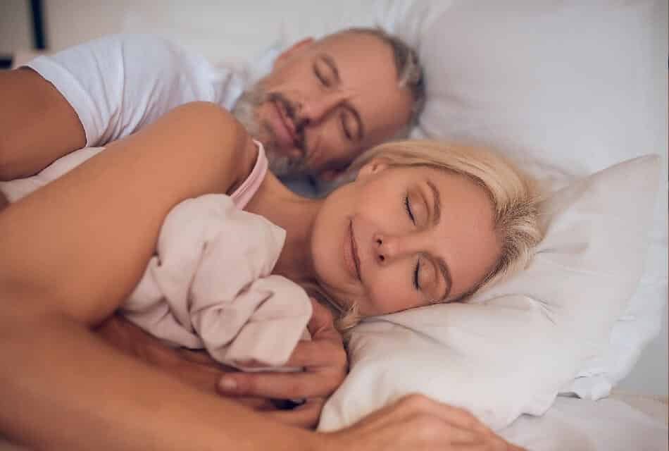 Couple sleeping comfortably in a bed