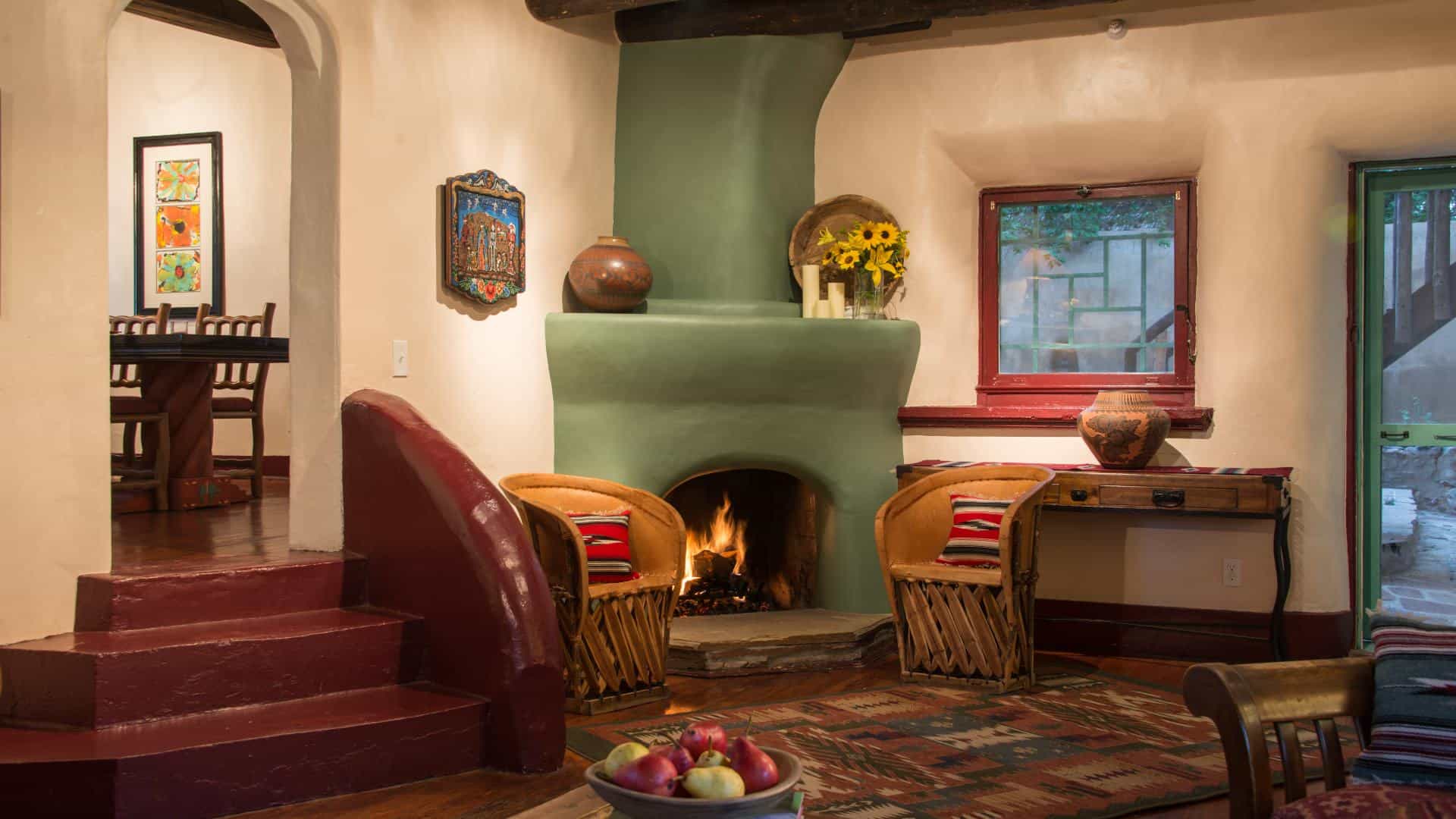 Large gathering room with hardwood floors, cream walls, sitting area, and green painted fireplace