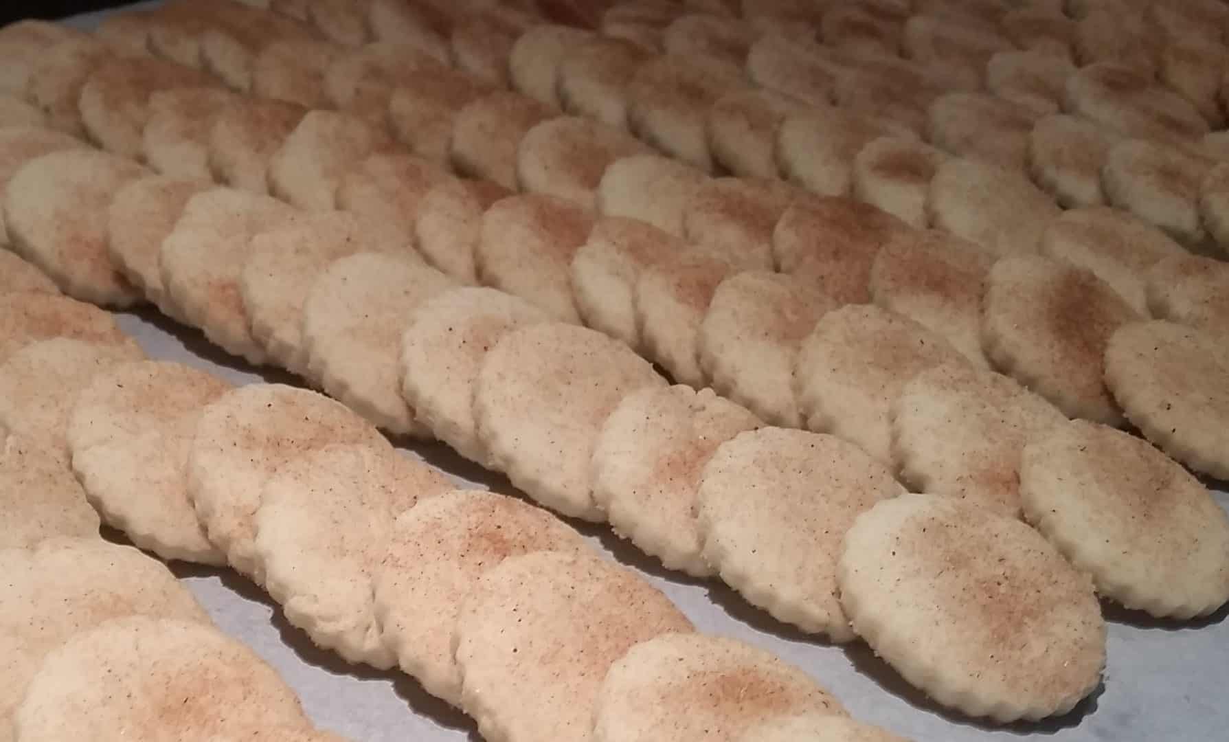 Rows of fresh baked bizcochito cookies on a baking sheet