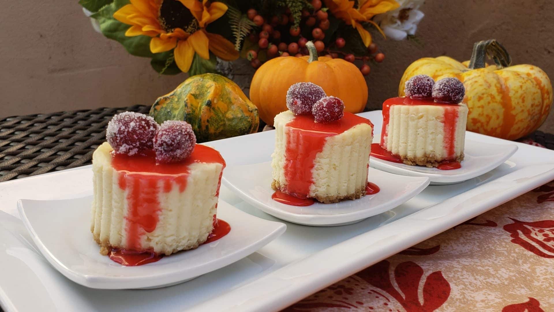 Three mini cheesecakes|Front of Santa Fe Inn at Christmas time|Elegant southwestern dining room with adobe walls and Christmas tree|Rows of fresh baked bizcochito cookies on a baking sheet