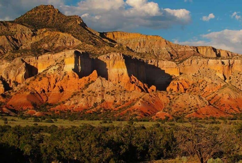 Southwestern mountain range with multiple striations of red and gold.