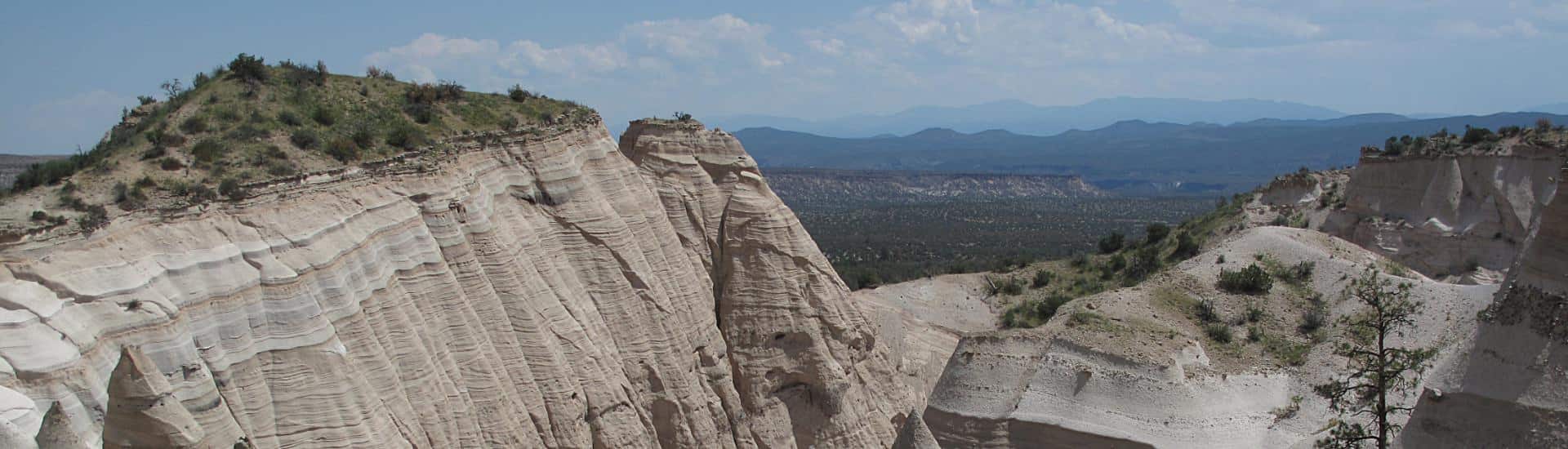 View of white mesas with mountains in the background