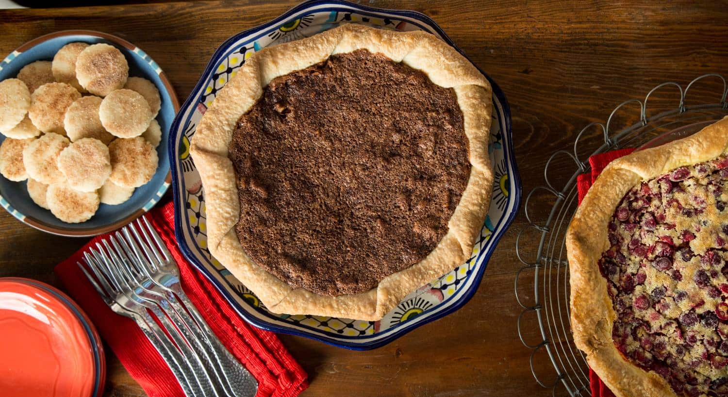 Close up view of a variety of pies and cookies on wooden table