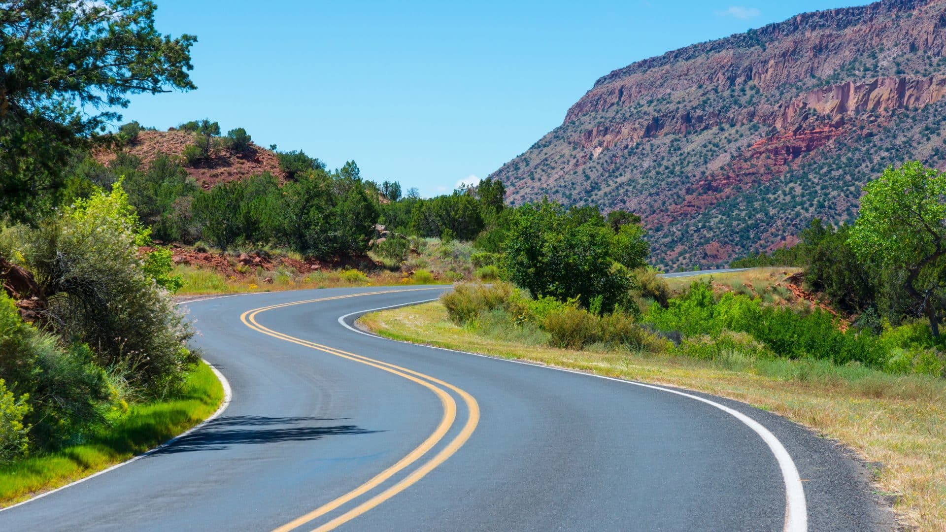 Winding paved road through desert and pastel colored mountains