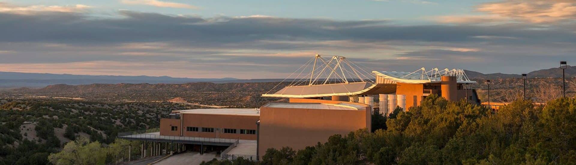 Aerial view of the Santa Fe Opera, an orange uniquely shaped building with white roof. Photo by Robert Godwin.