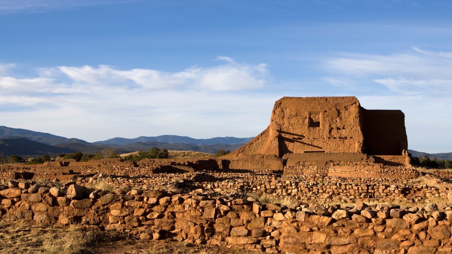 Adobe Pecos National Monument against brilliant blue skies.