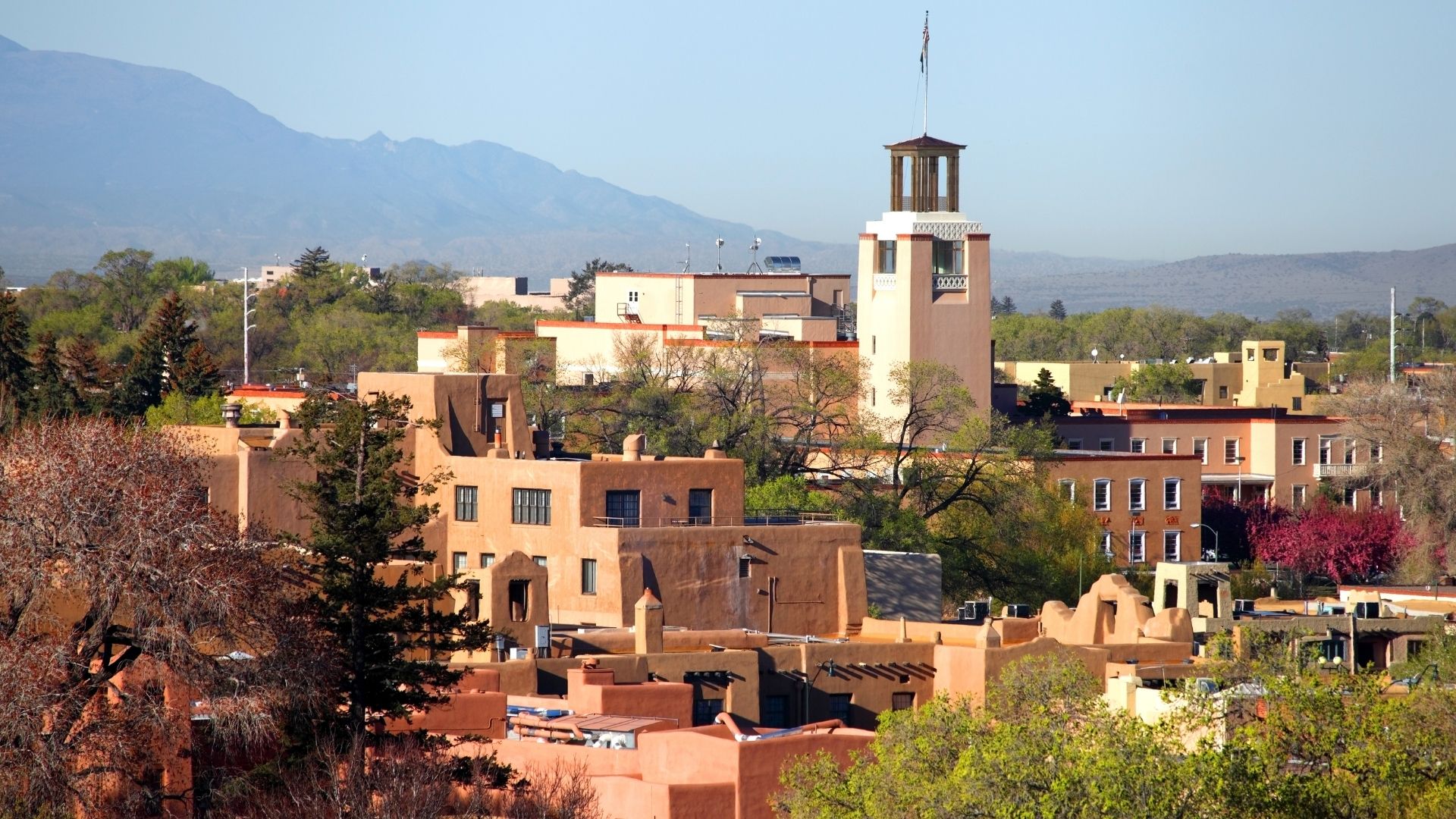 Aerial view of downtown Santa Fe with adobe buildings and moutains in the distance