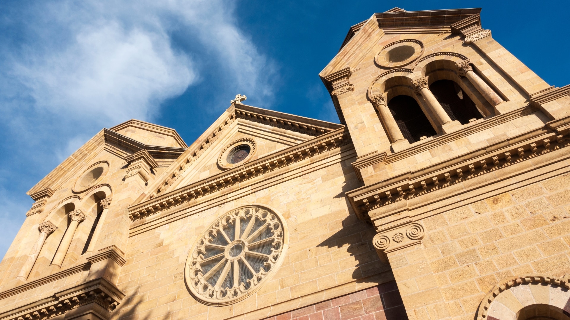 The brightly lit facade of Cathedral Basilica of St. Francis in downtown Santa Fe