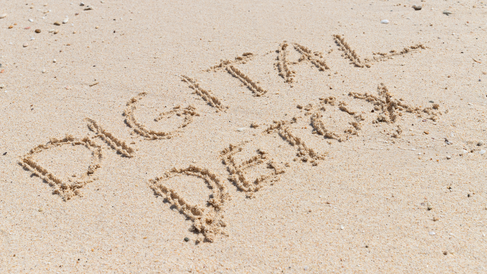 the words digital detox written in the sand