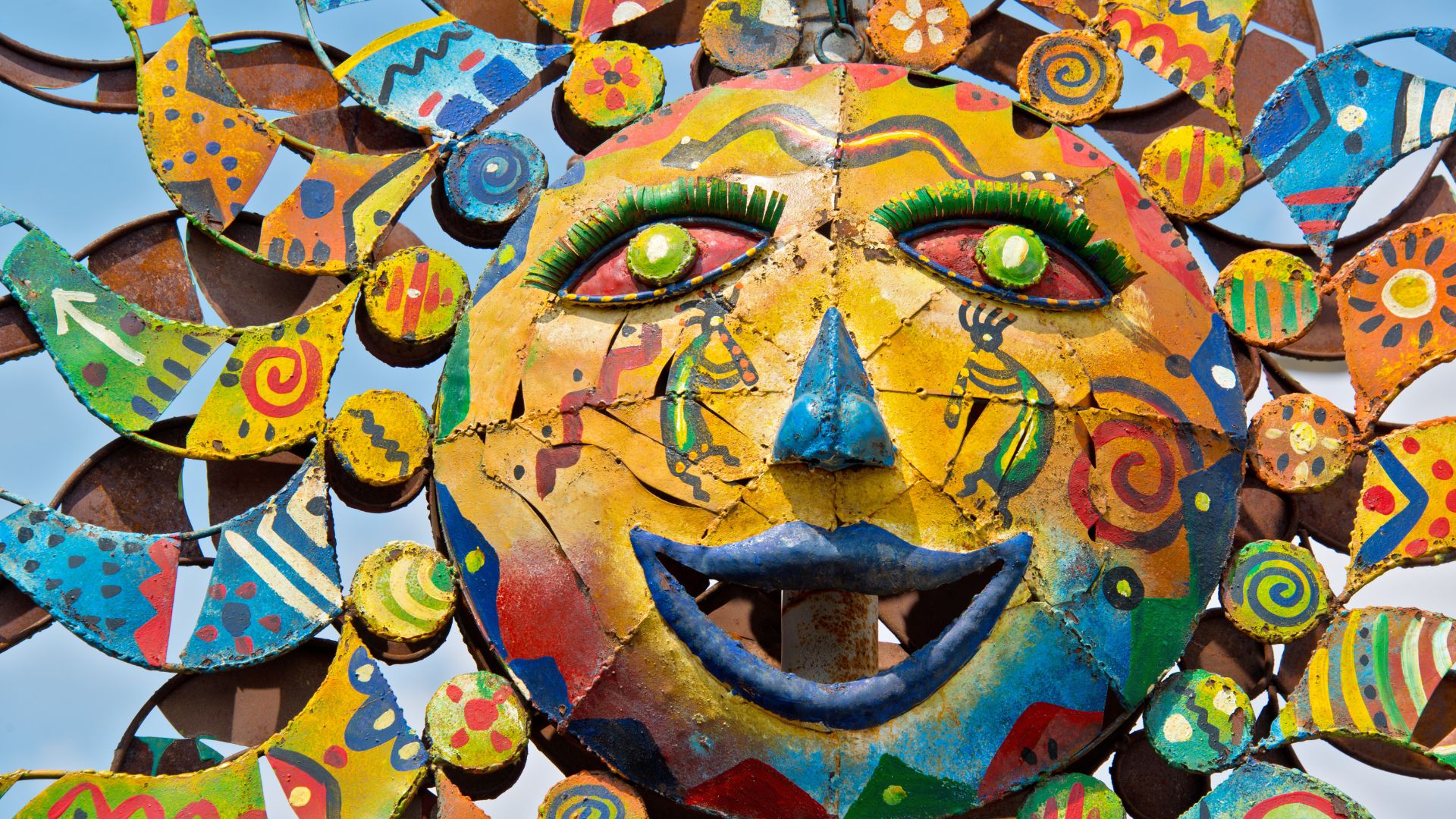 Large, colorful folk art display of a giant sun.