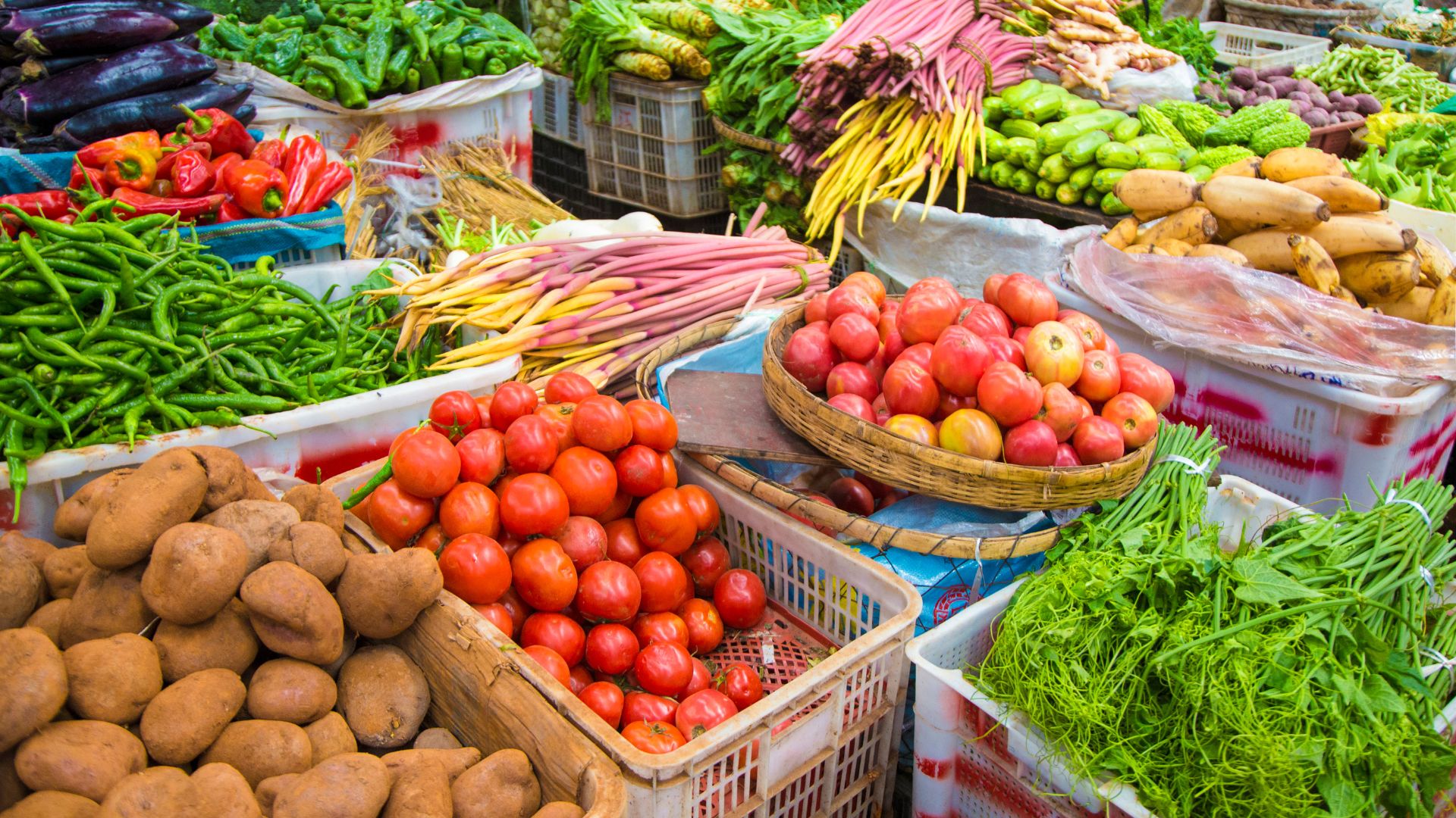 Baskets and boxes full of a variety of colorful fruits and vegetables at a market