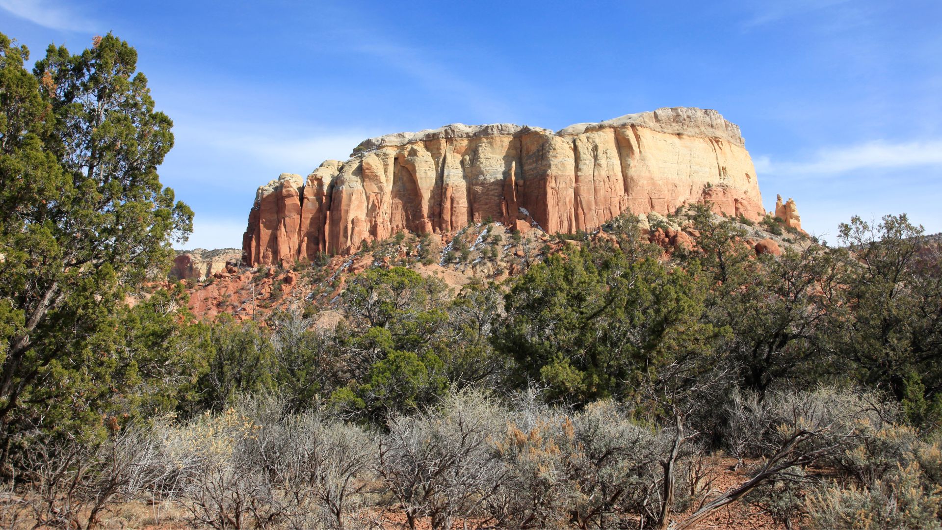 Kitchen Mesa is a tall, smooth-walled mesa of red rock surrounded by piñon juniper forest.