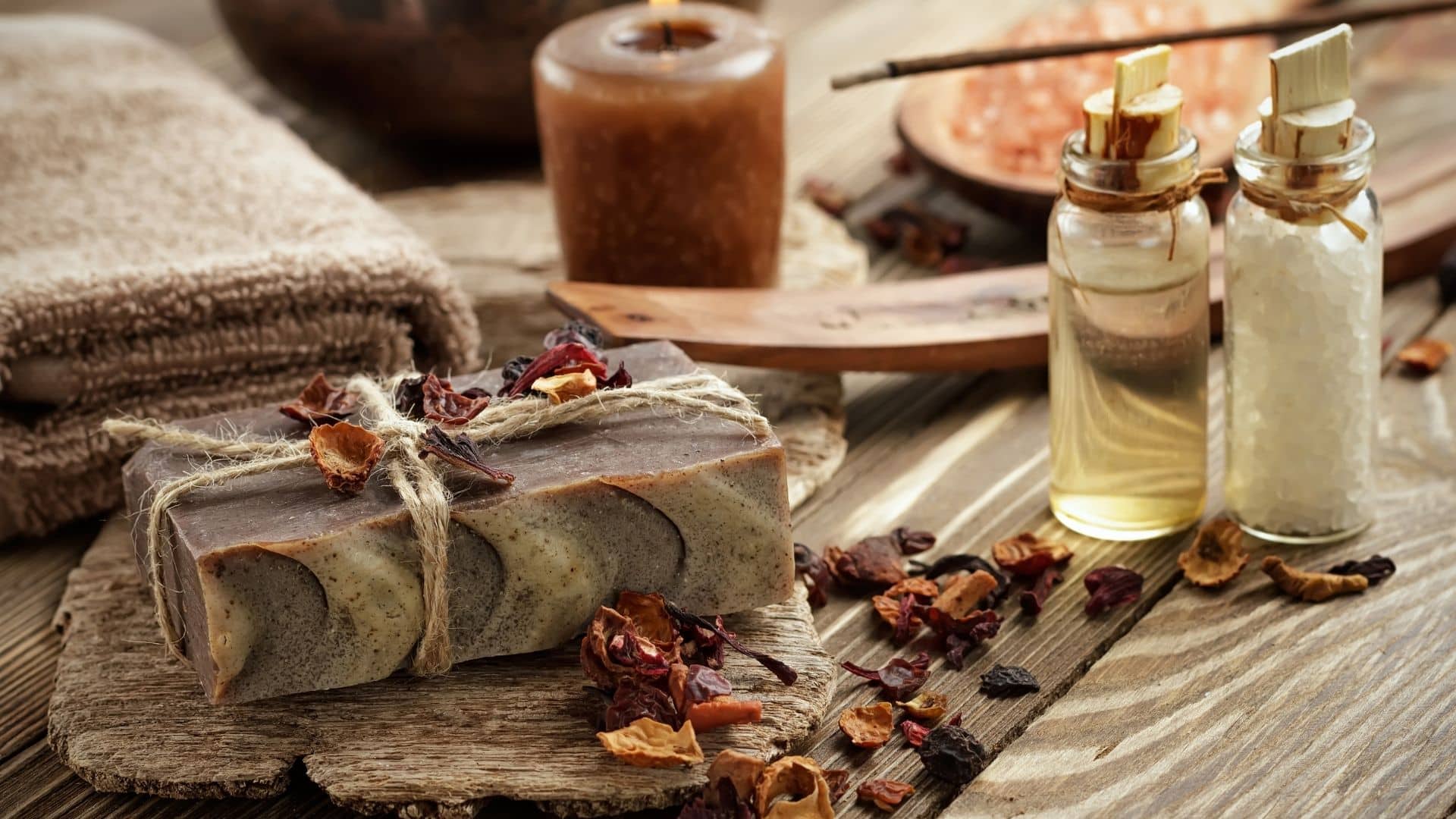 Table topped with spa supplies: candle, towells, essential oils