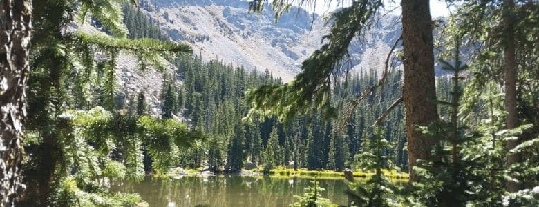 Stunning view of Nambe Lake surrounded by evergreen trees and mountains.|Hyde Park Circle near Santa Fe NM with mountainous views