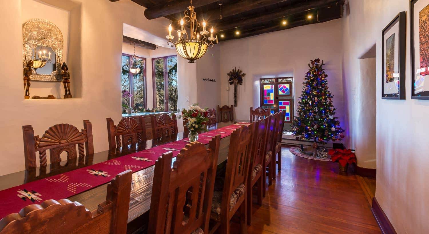 Large dining area with hardwood floors, wooden table and chairs, and Christmas tree