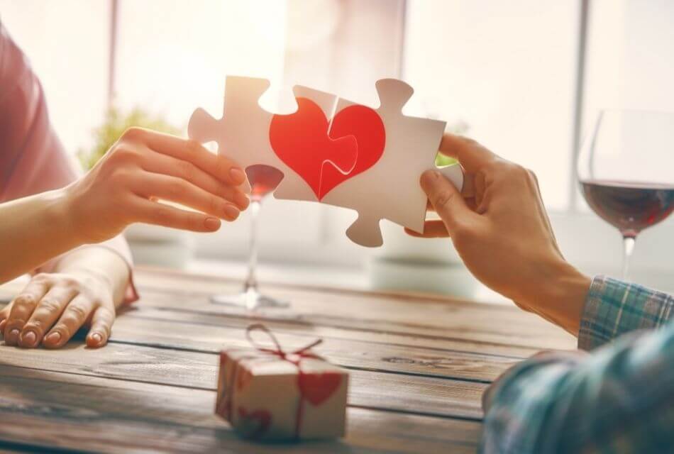 Couple at a table holding a Valentine puzzle